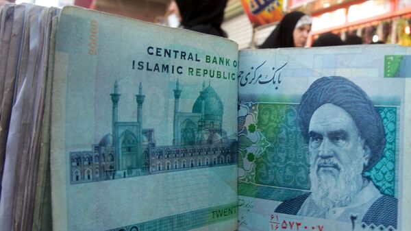 An Iraqi money dealer counts Iranian rial banknotes bearing a portrait of the late founder of the Islamic Republic of Iran, Ayatollah Ruhollah Khomeini, at an exchange office in Baghdad on February 3, 2012. - Sputnik Mundo