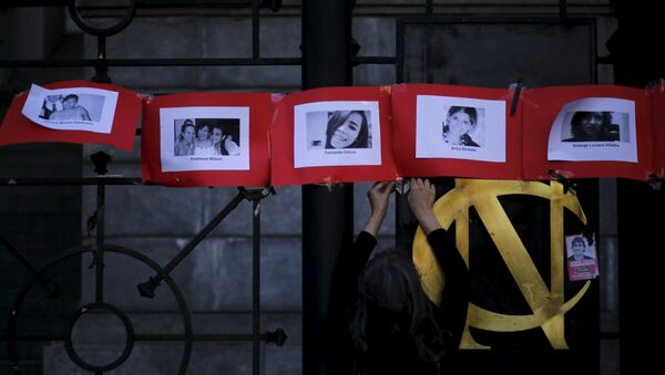 Fotos de las víctimas de feminicidio en Argentina durante una manifestación en el Día Internacional contra la Violencia de Género - Sputnik Mundo