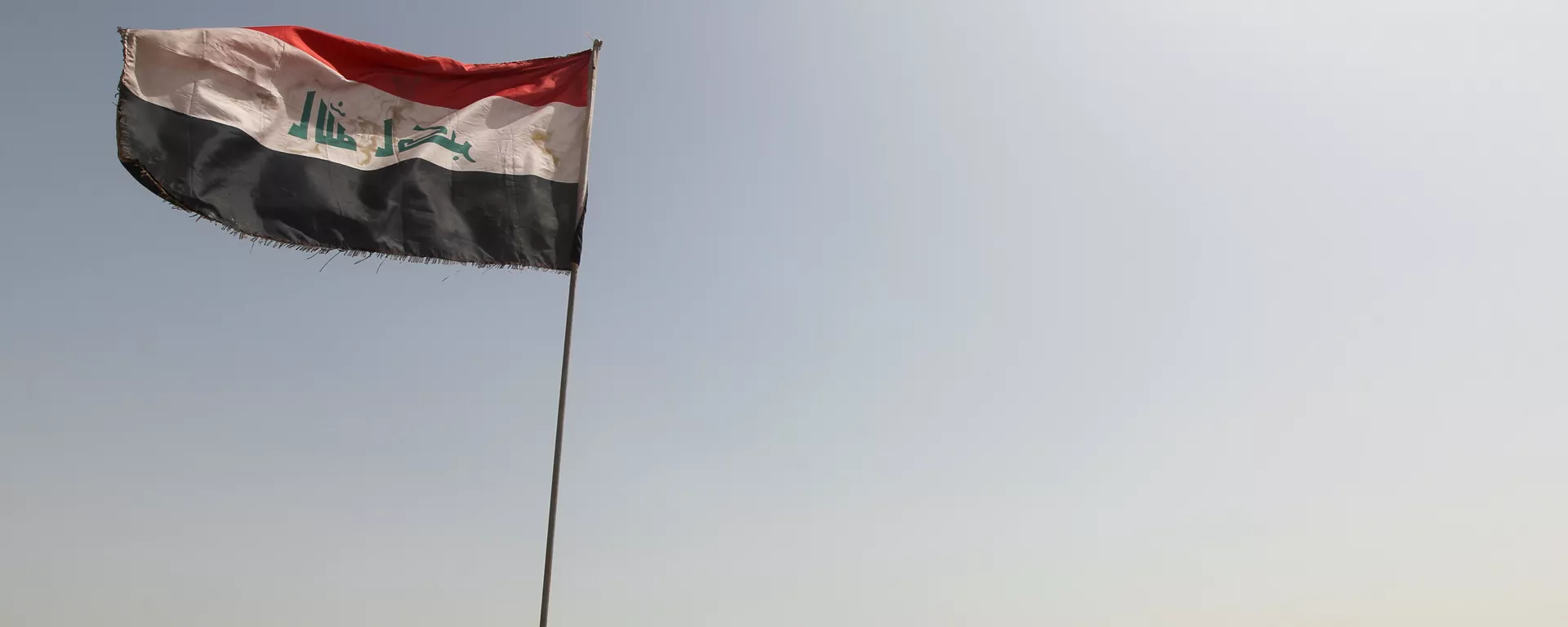 Iraqi forces stand by armed vehicles parked near an Iraqi flag as they patrol an area in the Garma district, west of the Iraqi capital Baghdad - Sputnik Mundo, 1920, 20.04.2024