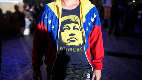 A pro-government supporter wears a T-Shirt with image of Venezuela's late President Hugo Chavez, as he waits for results during congressional elections in Caracas, Venezuela, Sunday, Dec. 6, 2015 - Sputnik Mundo