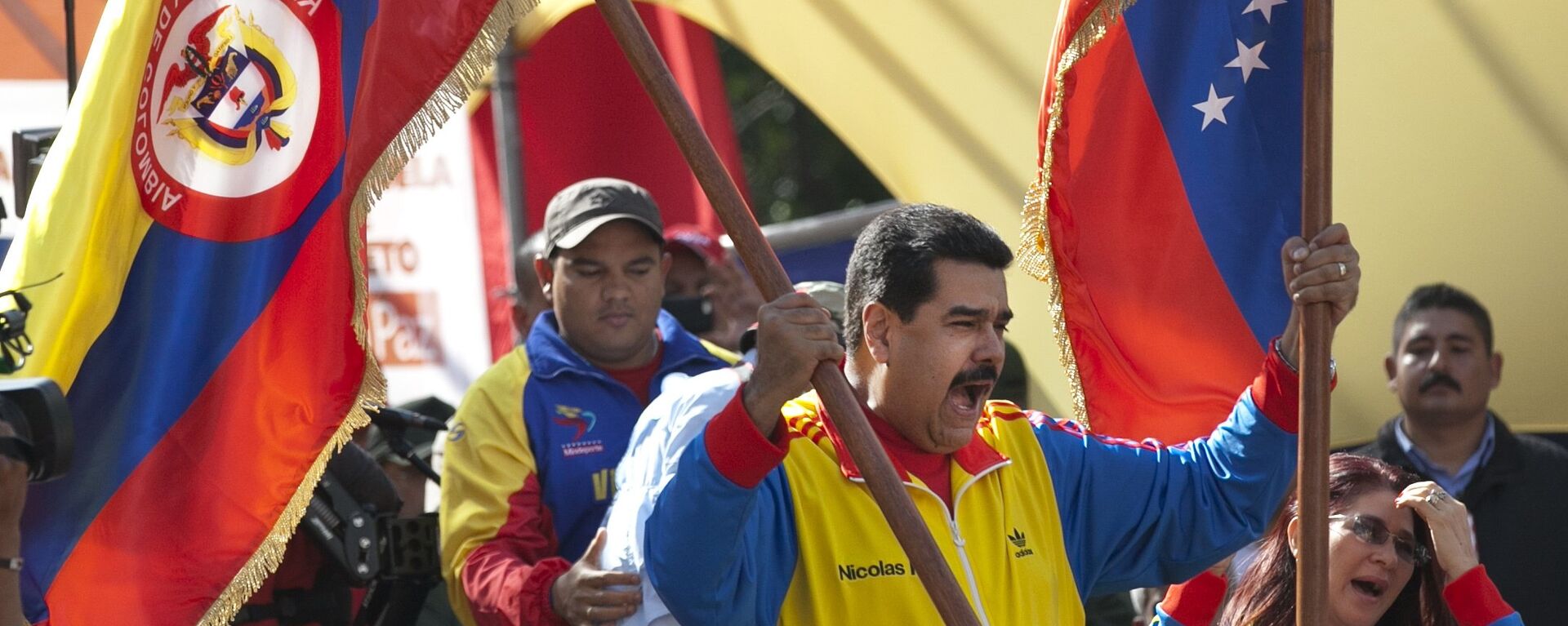 Venezuela's President Nicolas Maduro holds up a Colombian national flag, left, alongside his country's national flag, during a rally in support of closing the Colombian border, in Caracas, Venezuela, Friday, Aug. 28, 2015. - Sputnik Mundo, 1920, 02.06.2022