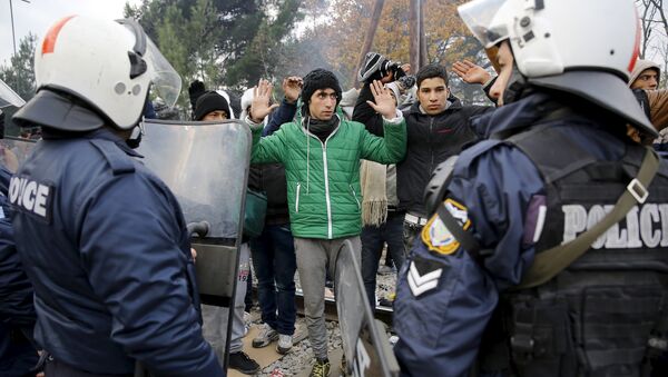 Refugiados de Marruecos enfrente del cordón de policía griega en la fronera con Macedonia - Sputnik Mundo