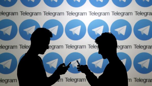 Two men pose with smartphones in front of a screen showing the Telegram logos in this picture illustration taken in Zenica, Bosnia and Herzegovina November 18, 2015. - Sputnik Mundo
