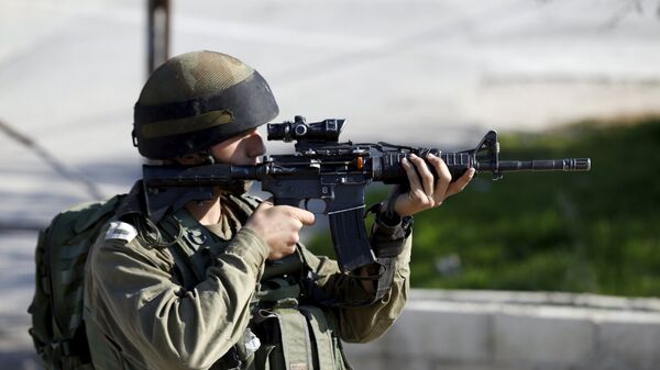 An Israeli soldier aims his weapon near the scene where a Palestinian was shot dead - Sputnik Mundo