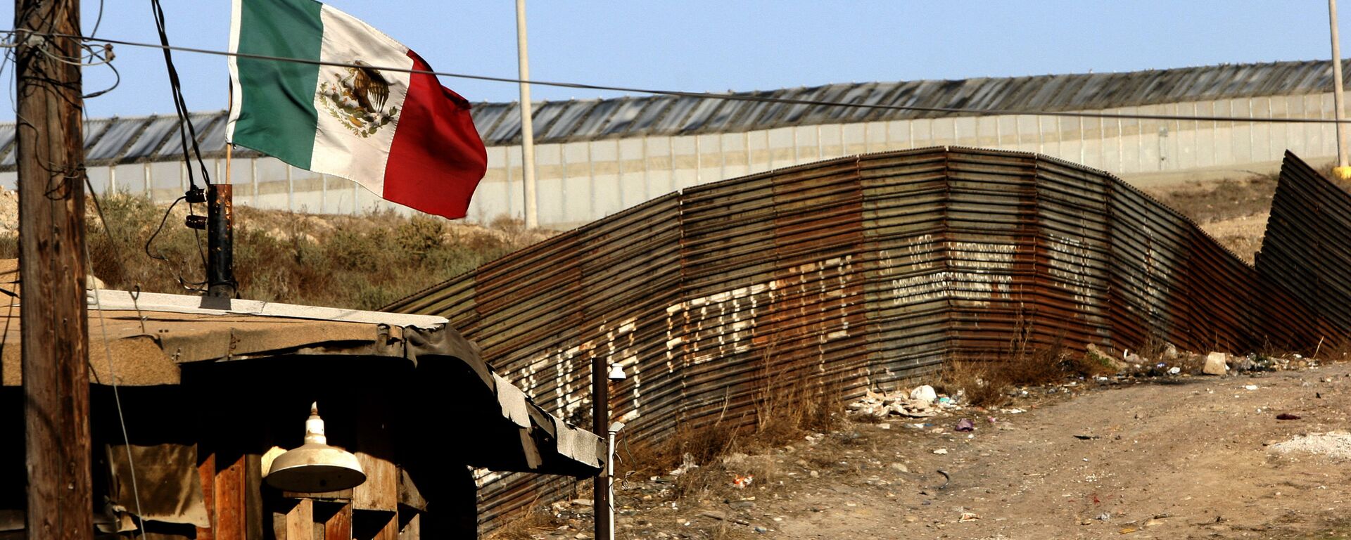 A Mexican flag waves close to the wall which separates Mexico from the United States 24 January 2006, in Tijuana, state of Baja California - Sputnik Mundo, 1920, 10.06.2021