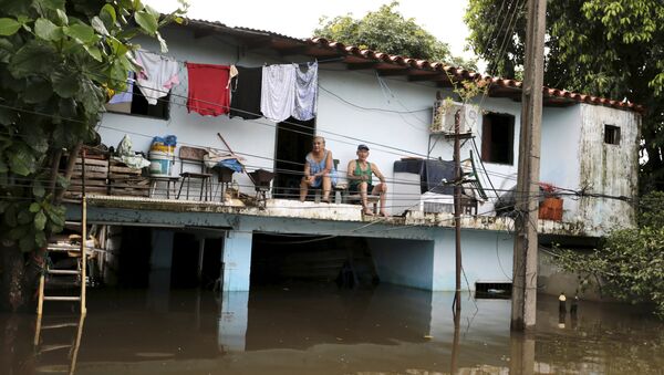 A family (top) sits in their house above flood waters in Asuncion, December 27, 2015 - Sputnik Mundo