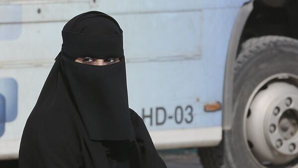A Saudi woman waits outside a polling center as she prepares to cast her ballot during the country's municipal elections in Riyadh, Saudi Arabia - Sputnik Mundo