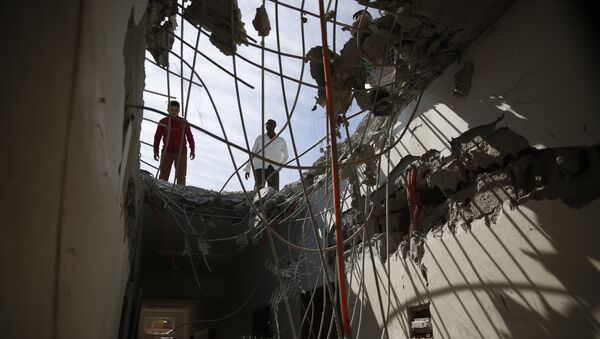Hombres ispeccionan edificios dañados durante el bombardeo de Arabia Saudí en Sanaa - Sputnik Mundo