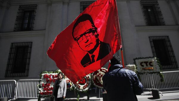 Un hombre alza la bandera con la cara de Salvador Allende frente al Palacio de La Moneda en Chile (archivo) - Sputnik Mundo
