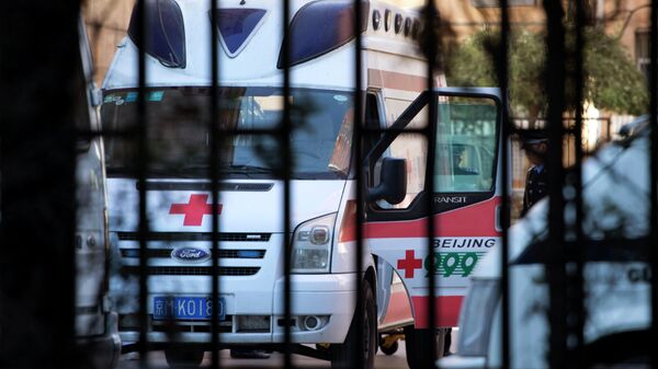 A Chinese police officer stands near an ambulance taking Ji Zhongxin away after his sentencing at the Beijing Chaoyang District Court in Beijing, China, Tuesday, Oct. 15, 2013 - Sputnik Mundo