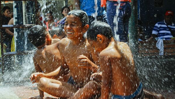 Niños colombianos deportados de Venezuela se bañan bajo un grifo a orillas del río Táchira, Cucuta, Colombia, el 30 de agosto de 2015 - Sputnik Mundo