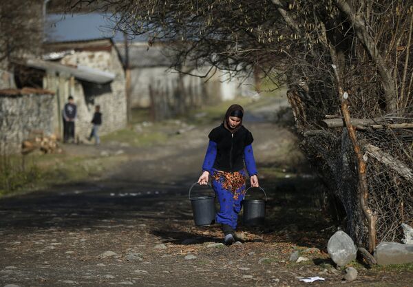 Mujer de la villa de Tsinubani en Pankisi con baldes de agua. - Sputnik Mundo