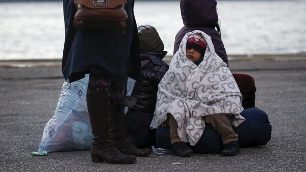 A migrant girl is covered with a blanket as refugees and migrants arrive aboard the passenger ferry Nissos Rodos at the port of Piraeus, near Athens, Greece, January 13, 2016. - Sputnik Mundo