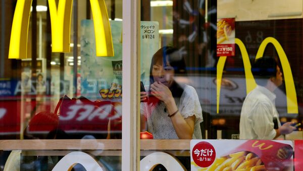 A woman uses her smartphone inside a McDonald's restaurant in Tokyo on July 23, 2014. - Sputnik Mundo