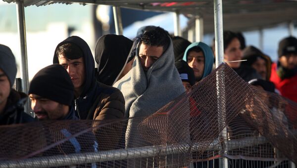 Migrantes y refigiados en una cola para recibir comida esperando cruzar frontera entre Gracia y Macedonia - Sputnik Mundo