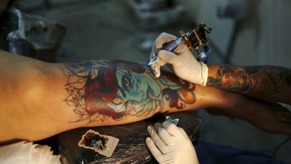 An artist works on a tattoo on the leg of a woman during the third International Tattoo Week Rio 2016 festival in Rio de Janeiro, Brazil - Sputnik Mundo