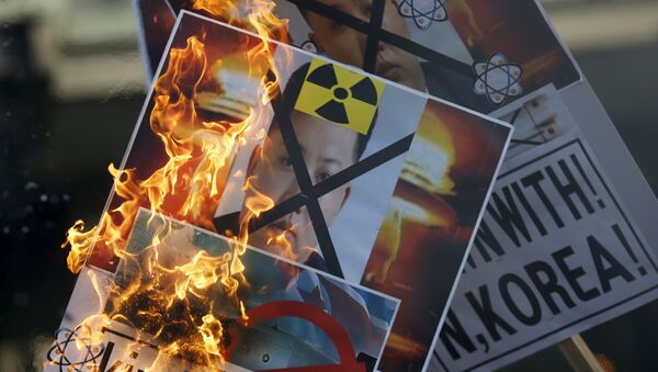 Un manifestante quema una pancarta con la imágen del líder norcoreano Kin Jong-un en Seúl, Corea del Sur - Sputnik Mundo