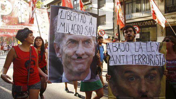 Los manifestantes con los posters con el president Macri durante una protesta - Sputnik Mundo