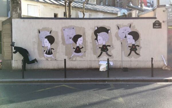 Obra de Fred Le Chevalier, artista callejero de París, contra el fondo de su obra dedicada a los atentados terroristas en París de noviembre de 2015 - Sputnik Mundo
