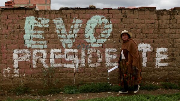 Una mujer camina frente a un mural que promueve la candidatura de Evo Morales - Sputnik Mundo