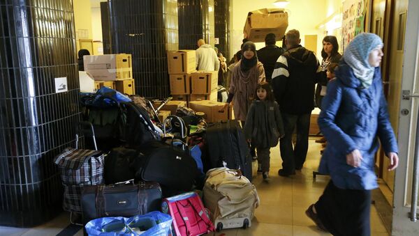 Migrants carry their goods upon their arrival at a refugee shelter in Friedenau city hall in Berlin's Tempelhof-Schoeneberg district, Germany - Sputnik Mundo