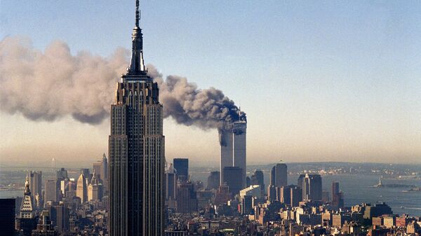In this Sept. 11, 2001, file photo, the twin towers of the World Trade Center burn behind the Empire State Building in New York. - Sputnik Mundo