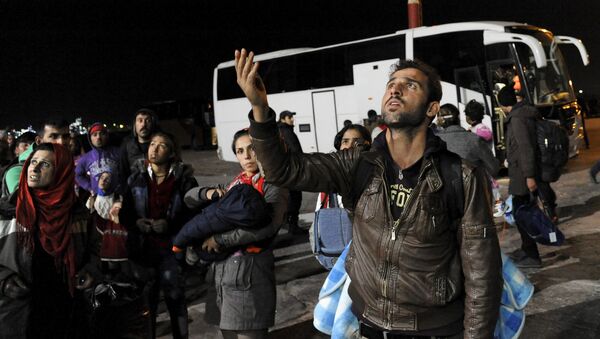 Refugees and migrants wait to board busses heading to shelters, following their arrival aboard the Blue Star Patmos passenger ship at the port of Elefsina, near Athens, Greece - Sputnik Mundo