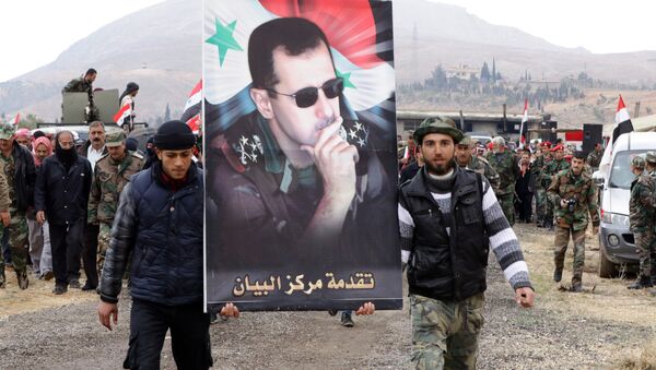 Voluntarios sirios llevan la imagen del presidente del país, Bashar Asad - Sputnik Mundo