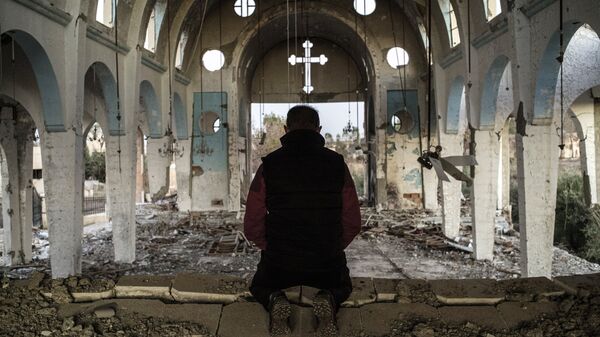 Cristiano sirio en una iglesia destruida en una aldea liberada de Daesh - Sputnik Mundo