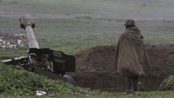 Un soldado de la autodefensa de Nagorno Karabaj cerca de un cañon de artillería - Sputnik Mundo