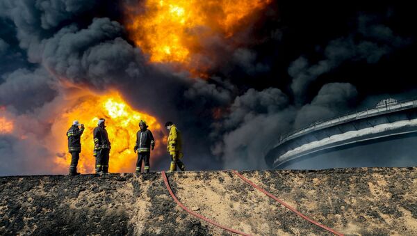 Los bomberos en el lugar del incendio en los depóstios petroleros en Ras Lanuf, Libia - Sputnik Mundo
