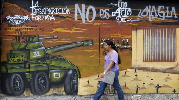 A woman walks in front of a mural during a commemoration day to show solidarity with the victims of armed conflict, in Cali, Colombia April 9, 2016 - Sputnik Mundo