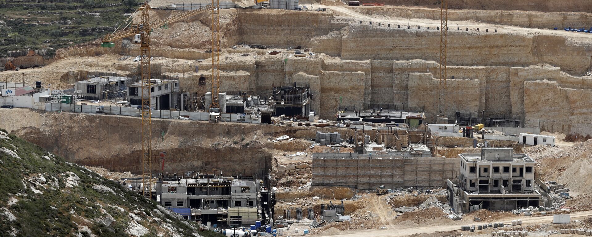 Obreros trabajan en una obra el 14 de abril de 2016 en el asentamiento israelí de Givat Zeev, cerca de la ciudad cisjordana de Ramala.  - Sputnik Mundo, 1920, 21.02.2023