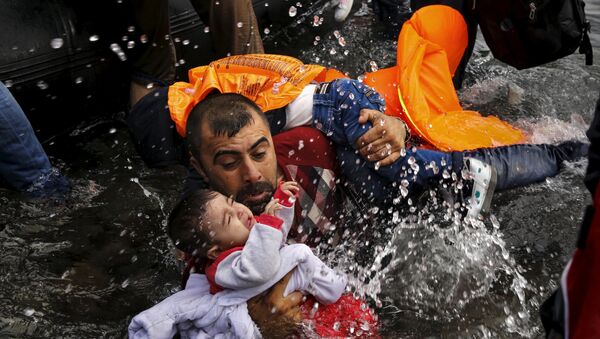 Un refugiado sirio con sus niños cerca de la isla griega de Lesbos - Sputnik Mundo