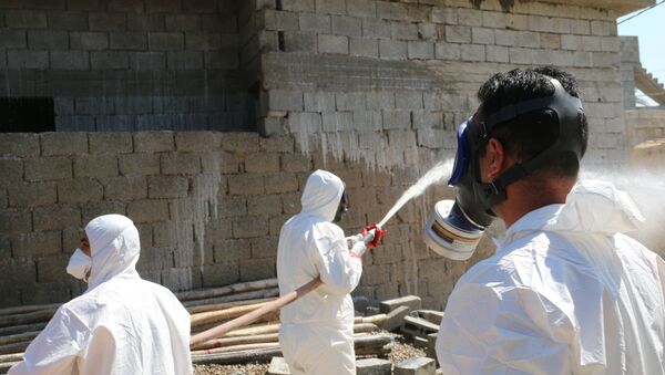Members of the civil defence spray and clean areas in the town of Taza, around 220 kilometres north of the capital Baghdad, on March 13, 2016, that might have been contaminated in a chemical attack carried out by the Islamic State (IS) group the previous week - Sputnik Mundo
