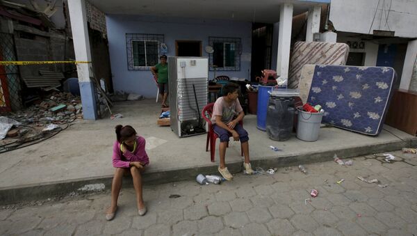 Ecuatorianos en frente de la casa en ruinas después del terremoto - Sputnik Mundo