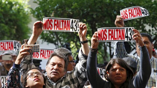 Activists hold a sign during the delivery of the final report of the 43 missing students from the Ayotzinapa teacher's training college by IACHR members, in Mexico City - Sputnik Mundo