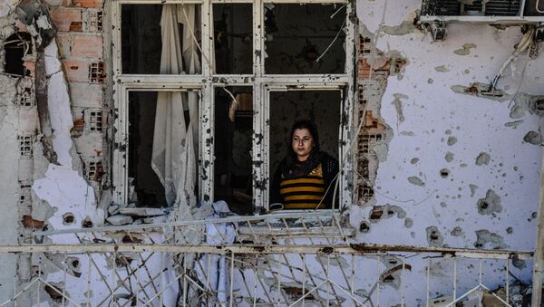 A woman looks through a window of her ruined house on March 8, 2016 during International Women`s day in Cizre district - Sputnik Mundo