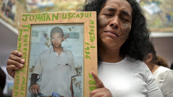 Una mujer con la foto de su hijo, desaparecido en el masacre de Trujillo por grupos paramilitares - Sputnik Mundo