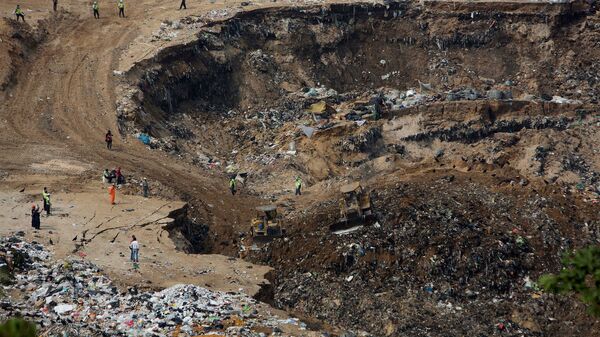 General view shows rescue workers and heavy machinery working at the site where a massive pile of garbage collapsed and buried several people at a landfill dumpsite in Guatemala City - Sputnik Mundo