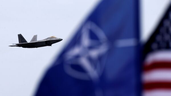 NATO and U.S. flags flutter as U.S. Air Force F-22 Raptor fighter flies over the military air base in Siauliai, Lithuania, April 27, 2016 - Sputnik Mundo