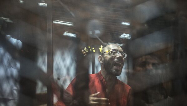 Ahmed Abdel-Aaty, the former head of Egypt's ousted Islamist president's office, wearing a red uniform, stands behind the defendant's bars during his trial at the police academy in Cairo on May 7, 2016 - Sputnik Mundo