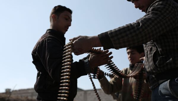 Opposition fighters belonging to Jaish al-Islam (Islam Army), the foremost rebel group in Damascus province who fiercely oppose to both the regime and the Islamic State group, check their ammunition belts in Tal al-Aswan in the area of the eastern Ghouta rebel bastion east of the Syrian capital, Damascus, during clashes with government forces on February 9, 2016. - Sputnik Mundo