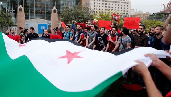 Protesters carry a giant Syrian opposition flag as they take part in a sit-in in solidarity with the people of Aleppo - Sputnik Mundo