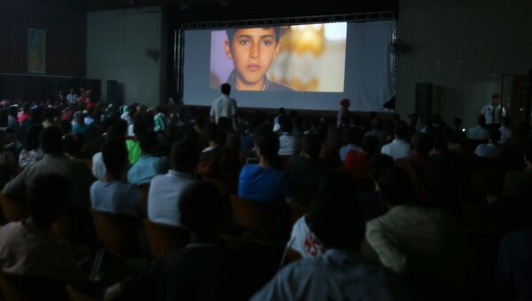 Las familias palestinas durante la proyección de una película en la inauguración del festival de cine La Alfombra Roja en la Franja de Gaza - Sputnik Mundo