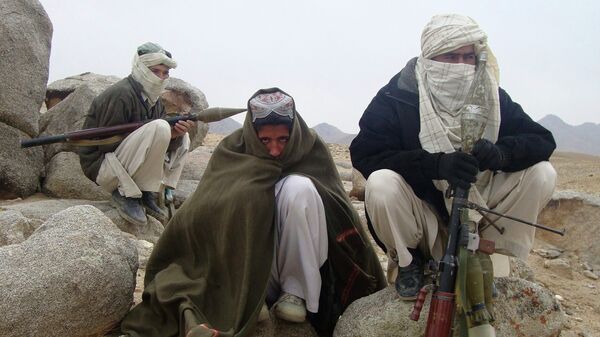 Taliban fighters pose with weapons - Sputnik Mundo