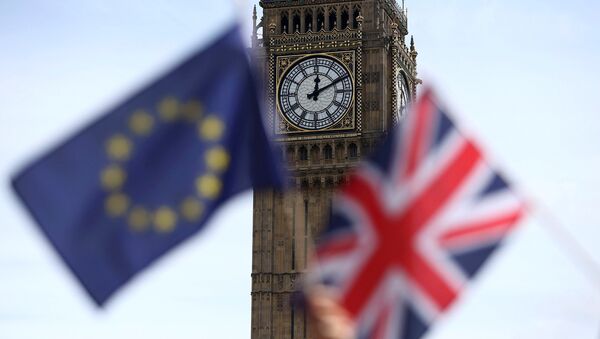 Participants hold a British Union flag and an EU flag during a pro-EU referendum event at Parliament Square in London. - Sputnik Mundo