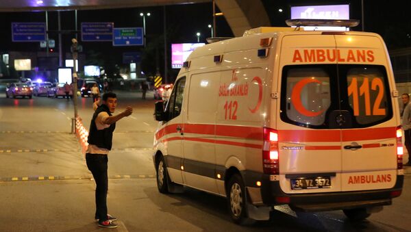 A policeman gestures in front of an ambulance at Istanbul Ataturk airport, Turkey, following a blast June 28, 2016. - Sputnik Mundo