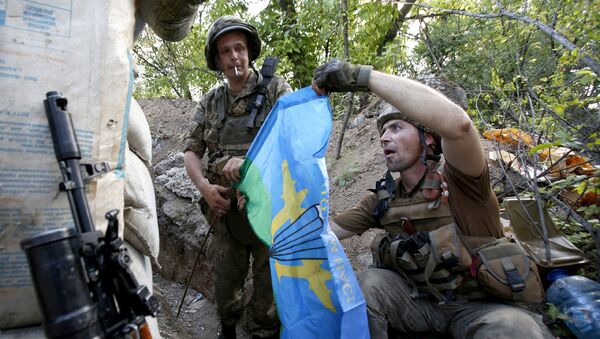 Servicemen of Ukrainian Forces holds a flag of Ukrainian Airborne Troops to set it on the frontline after a battle with pro-Russian separatists at Avdiivka, in Ukraine's Donetsk region on June 25, 2016. - Sputnik Mundo