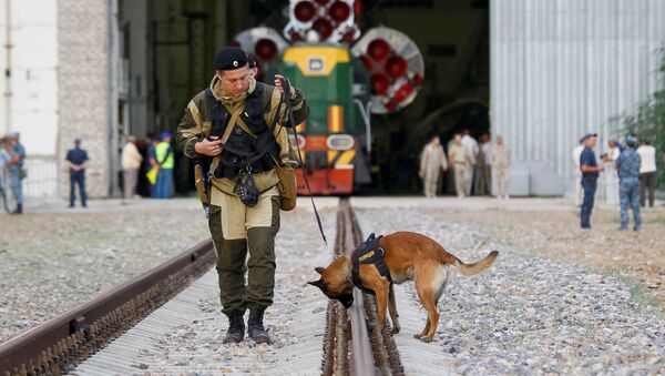 Полицейский с собакой перед ракетой-носителем Союз- ФГ с пилотируемым кораблем Союз-МС на космодроме Байконур - Sputnik Mundo